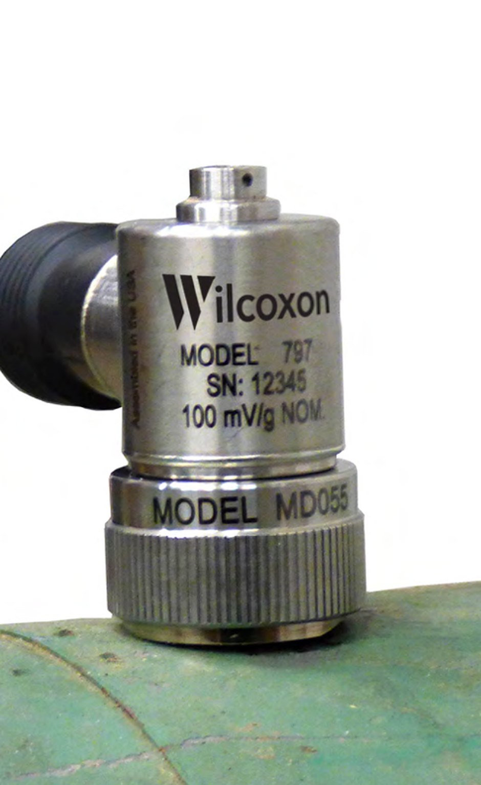 Sensor de vibración Wilcoxon 797 montado sobre base MD055 en la carcasa de una máquina, con su cable industrial conectado