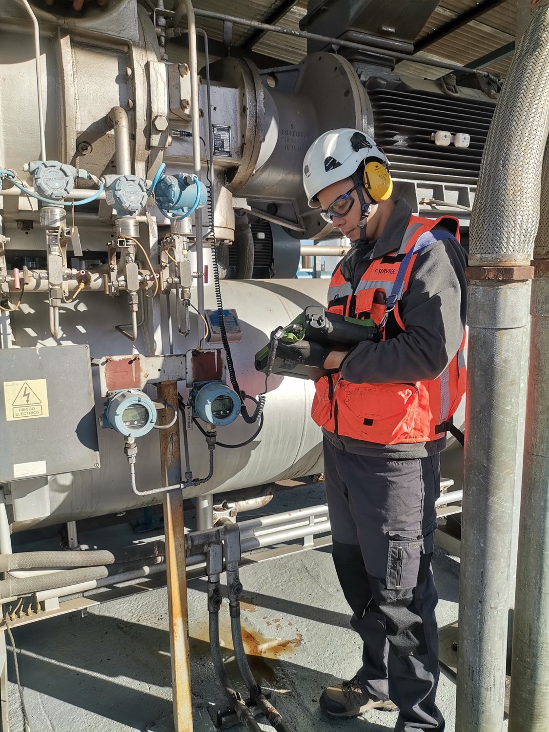 Técnico de Servige realizando análisis de vibraciones en terreno sobre un equipo rotativo